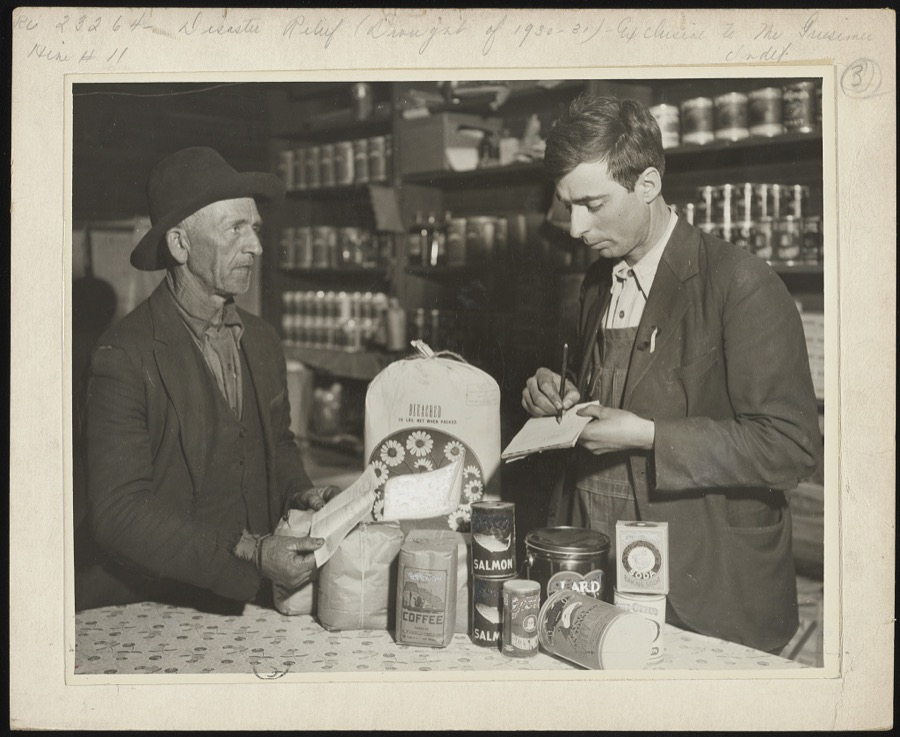 A storekeeper in a small lumber camp in the mountains of eastern Kentucky filling a Red Cross order for a family of four persons