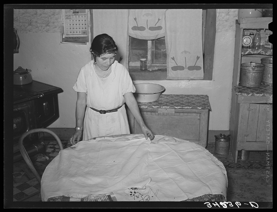 Spanish-American woman covering dough so that shaped loaves will rise evenly. Near Taos, New Mexico