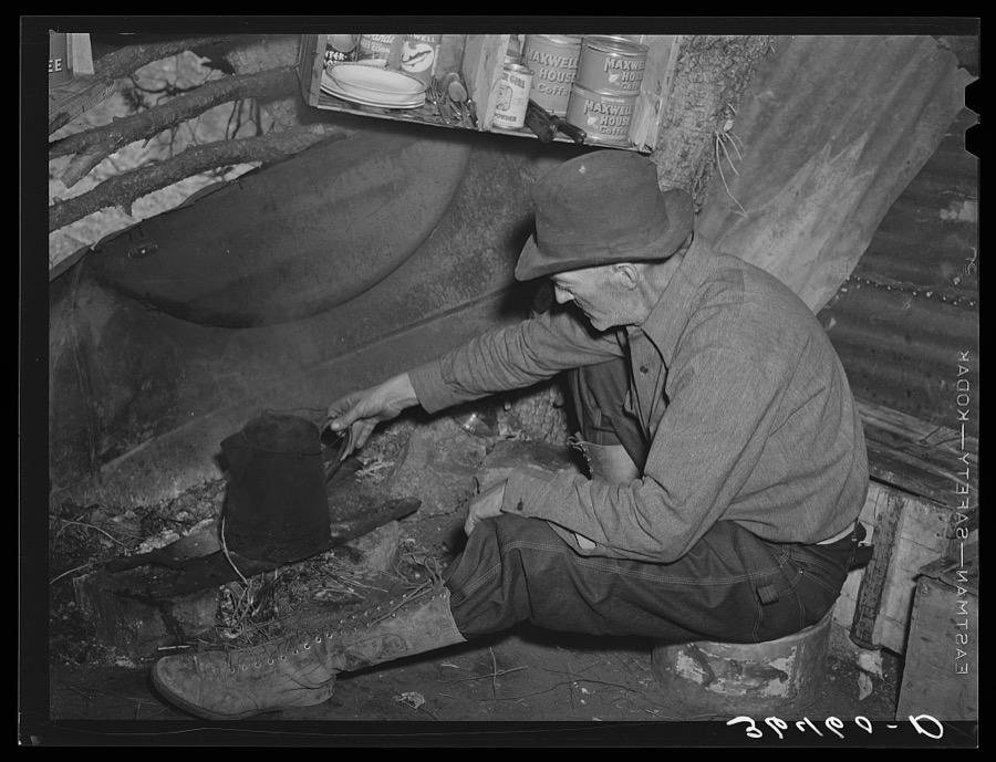 Eugene Davis, gold prospector, making a pot of coffee in his shack on his diggings at Pinos Altos, New Mexico
