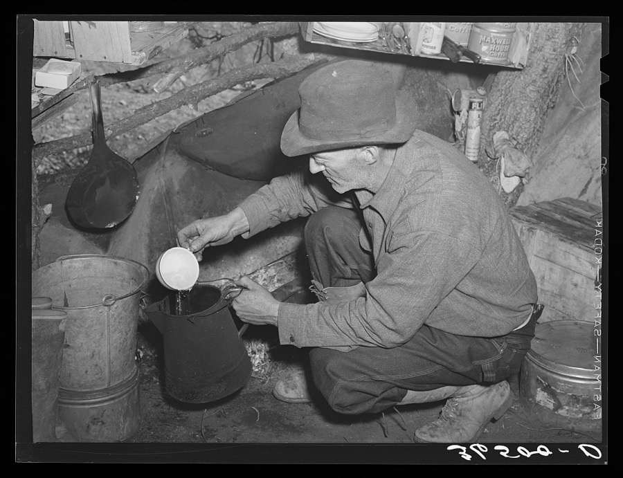 Eugene Davis, gold prospector, making a pot of coffee in his shack on his diggings at Pinos Altos, New Mexico
