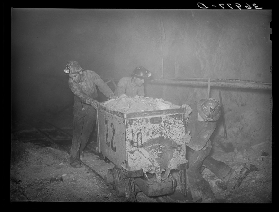 Pushing a car load of gold ore along track in mine. Mogollon, New Mexico