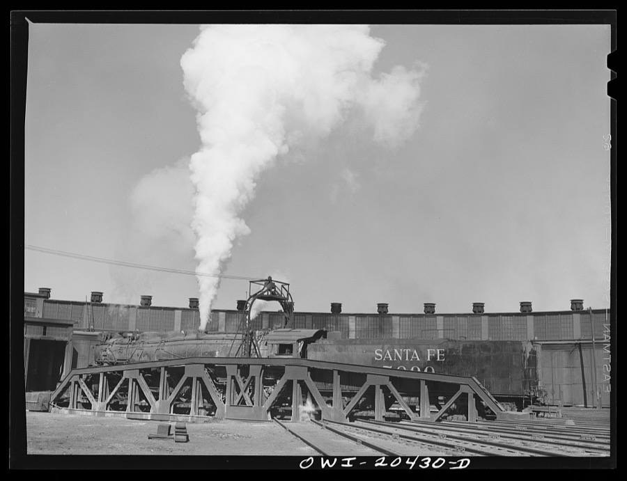Clovis, New Mexico. One of the giant 5000 Class engines coming out of the Atchison, Topeka and Santa Fe Railroad roundhouse for a run to Vaughn, New Mexico