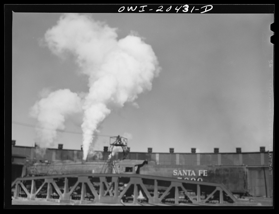 Clovis, New Mexico. One of the giant 5000 Class engines coming out of the Atchison, Topeka and Santa Fe Railroad roundhouse for a run to Vaughn, New Mexico