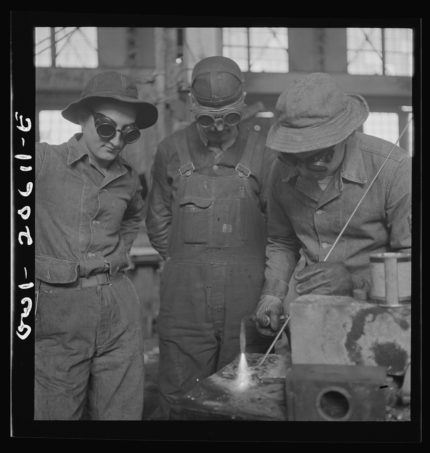 Clovis, New Mexico. Soldiers of the United States Army Railroad Battalion study welding at the locomotive shops in the Atchison, Topeka and Santa Fe Railroad. Left to right: Private Edward Dravis of Minnesota; Earl Weidinger, instructor and welder; and Sergeant Arthur Cannon of Indiana