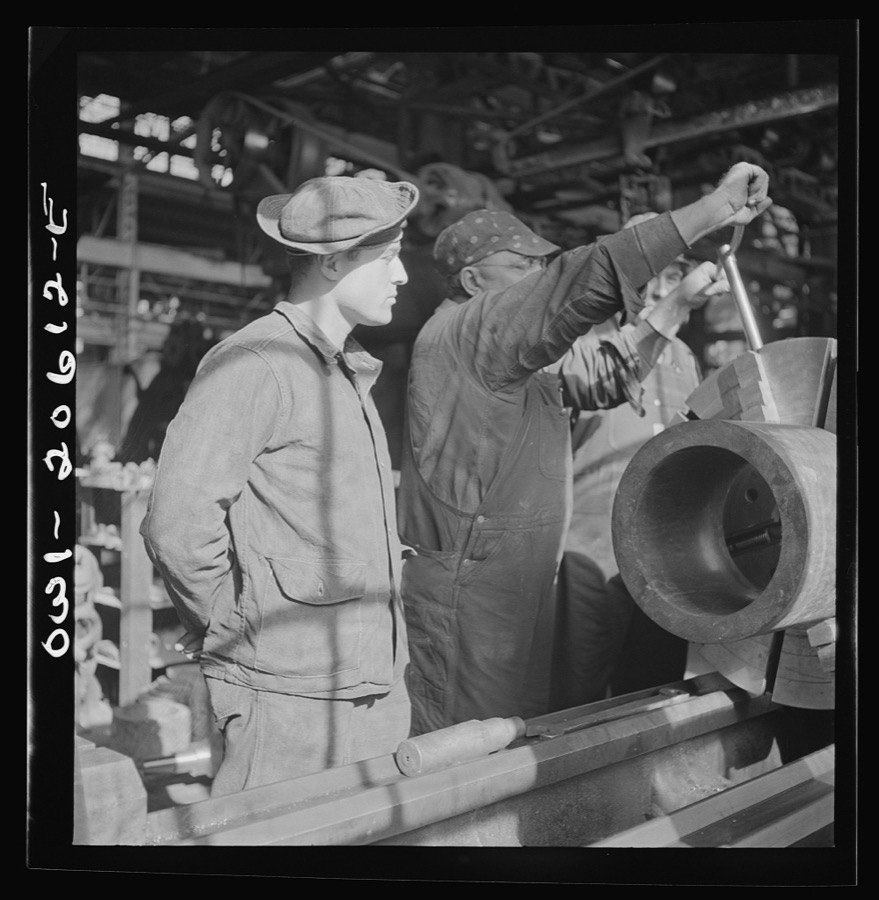 Clovis, New Mexico. A machinist in the Atchison, Topeka and Santa Fe Railroad locomotive shops, John Corey, working at an engine lathe making steel bushing with Sergeant Bowman of the United States Army Railroad Battalion who is stationed at Clovis