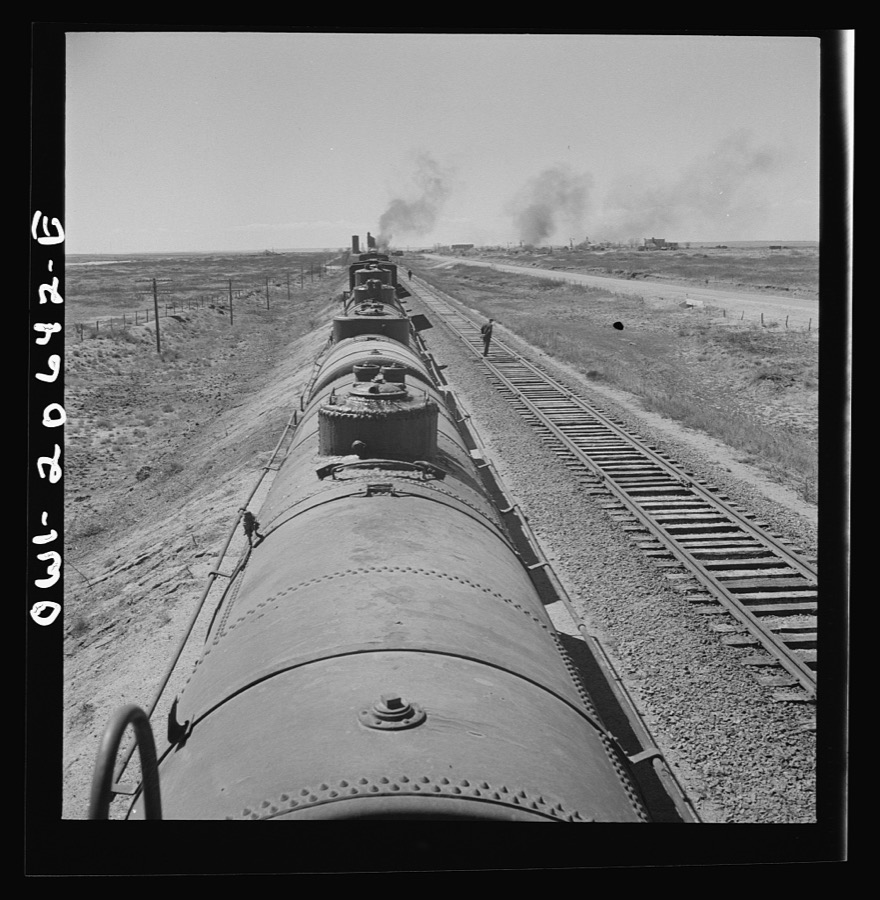 Tolar, New Mexico. Atchison, Topeka, and Santa Fe Railroad train between Clovis and Vaughn, New Mexico stopping for water. A brakeman walking the length of the train for inspection