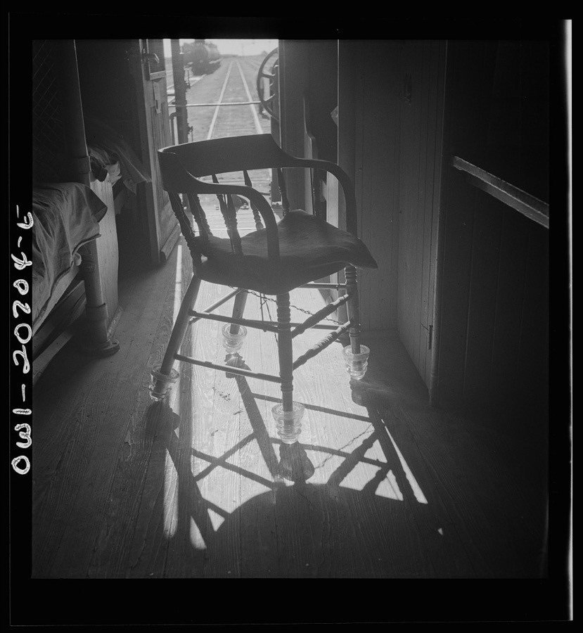 Vaughn, New Mexico. Conductor's chair in a caboose on the Atchison, Topeka and Santa Fe Railroad. Glass rollers on the legs are old insulators from telephone lines