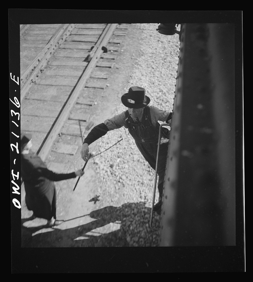 Dalies, New Mexico. Conductor C.W. Tevis picking up a message from a woman operator on the Atchison, Topeka and Santa Fe Railroad between Belen and Gallup, New Mexico