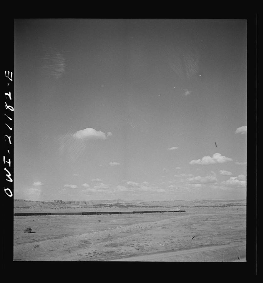South Chaves (vicinity), New Mexico. On the Atchison, Topeka and Santa Fe Railroad between Belen and Gallup, New Mexico, passing an eastbound passenger train