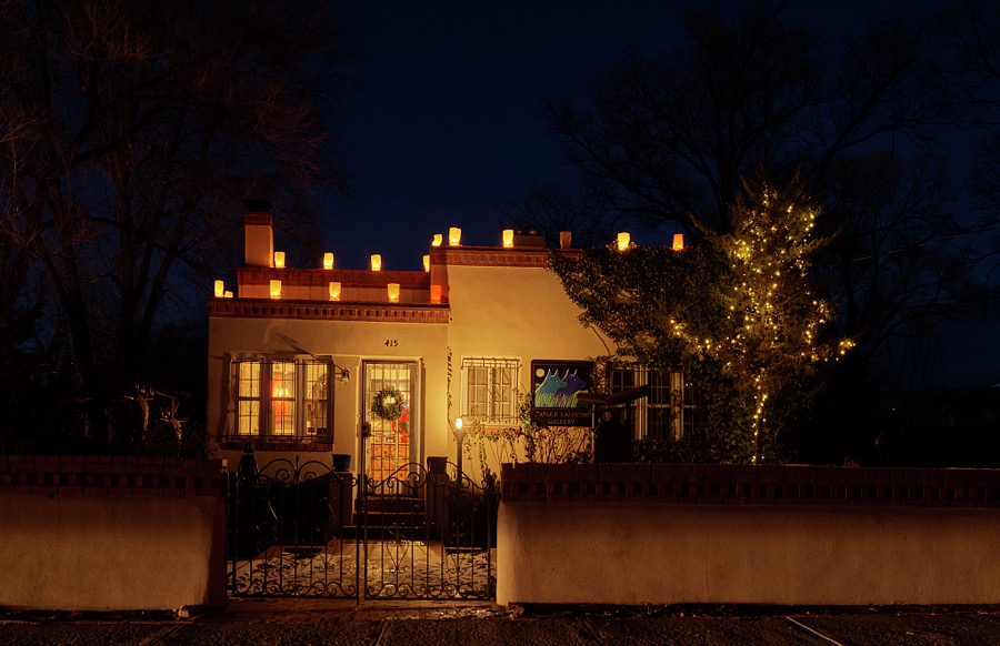 A Pueblo Adobe-style home in the Old Town district of Santa Fe, the capital city of the southwest U.S. state of New Mexico, photographed at dusk on Christmas Eve