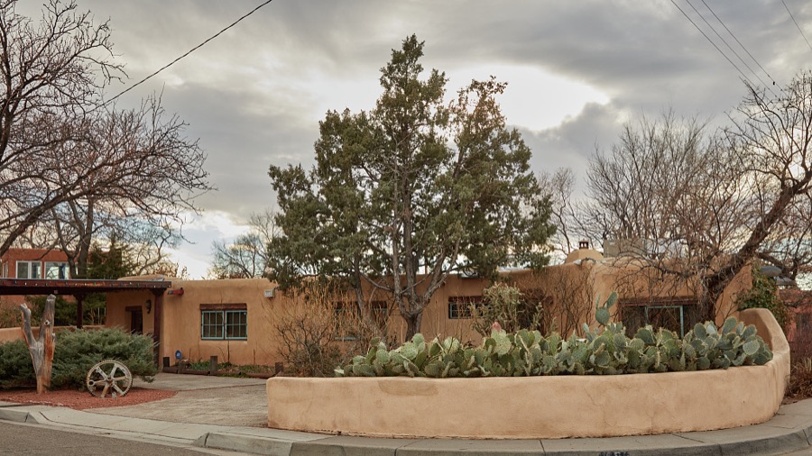 An adobe-style corner house with southwest-style landscaping in Albuquerque, the largest city in the southwest U.S. state of New Mexico