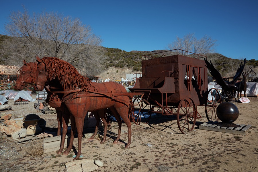 Metal-art horses and stagecoach displayed outside the Casa Cristal Pottery home-and-garden roadside store near Velarde in northern New Mexico