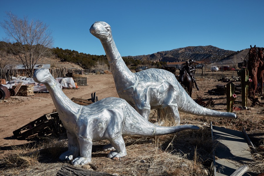 Metal-art dinosaurs displayed outside the Casa Cristal Pottery home-and-garden roadside store near Velarde in northern New Mexico