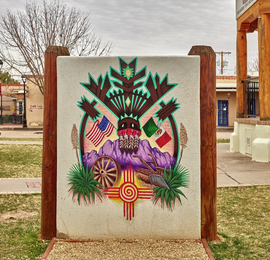 Art on the plaza of Mesilla (locally called Old Mesilla), a historic town adjacent to Las Cruces, the hub city of southern New Mexico, that includes the flags of the United States and Mexico, and the sunburst symbol of the New Mexico flag