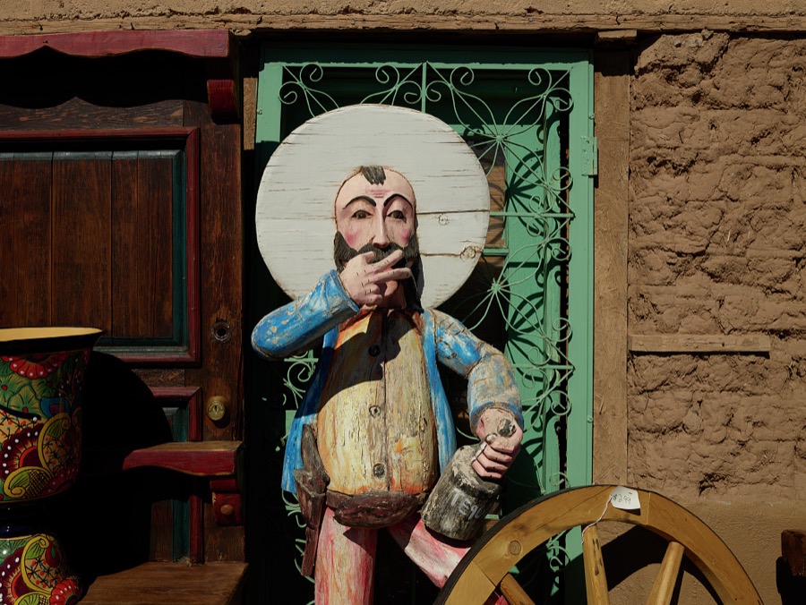 Drunken-sailor carving outside the Coyote Traders antique-and-collectibles store on Picacho Avenue, the old route into town on the west side of Las Cruces, the hub city of southern New Mexico, 27 miles from the border with far-western Texas