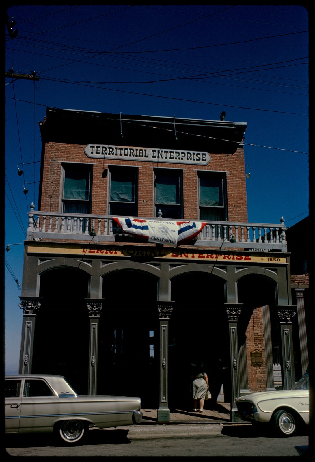 Front of Territorial Enterprise building with Centennial banner on balustrade, Virginia City, Nevada, Boston Public Library - undated