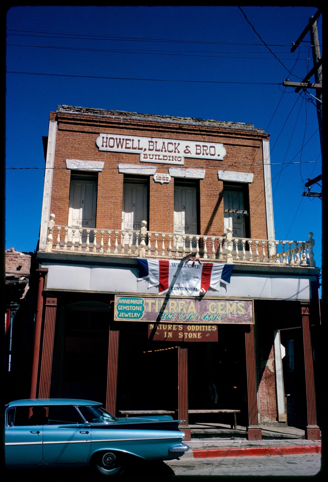 Front of Howell, Black & Bro. Building with Centennial banner hanging down, Virginia City, Nevada, Boston Public Library - undated