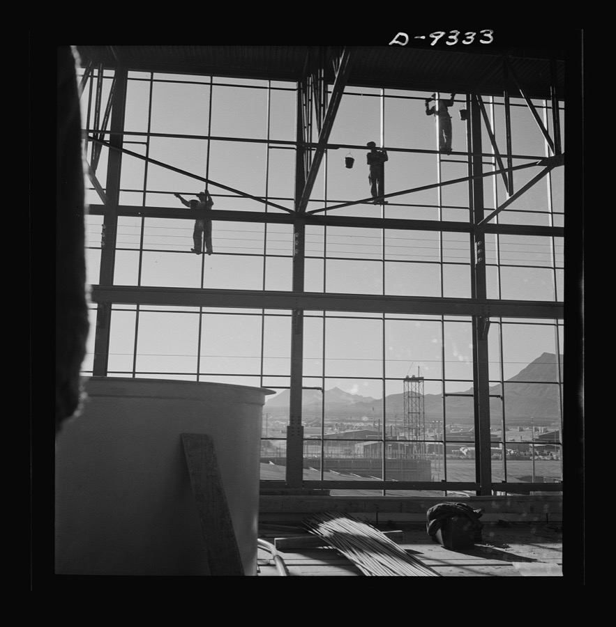 Production. Magnesium. Workmen seventy feet above ground are busily engaged in adding to the already gigantic proportions of Basic Magnesium's plant in the southern Nevada desert. A 24-hour production schedule results in turning out great quantities of magnesium for aircraft and tracer bullet manufacturers