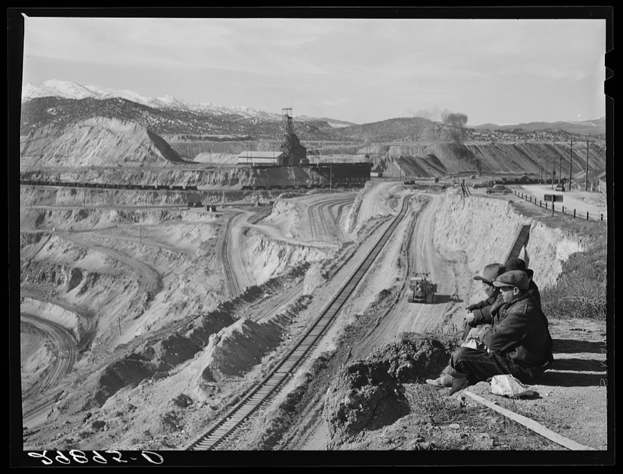 Workers sitting at edge of copper pit. Ruth, Nevada