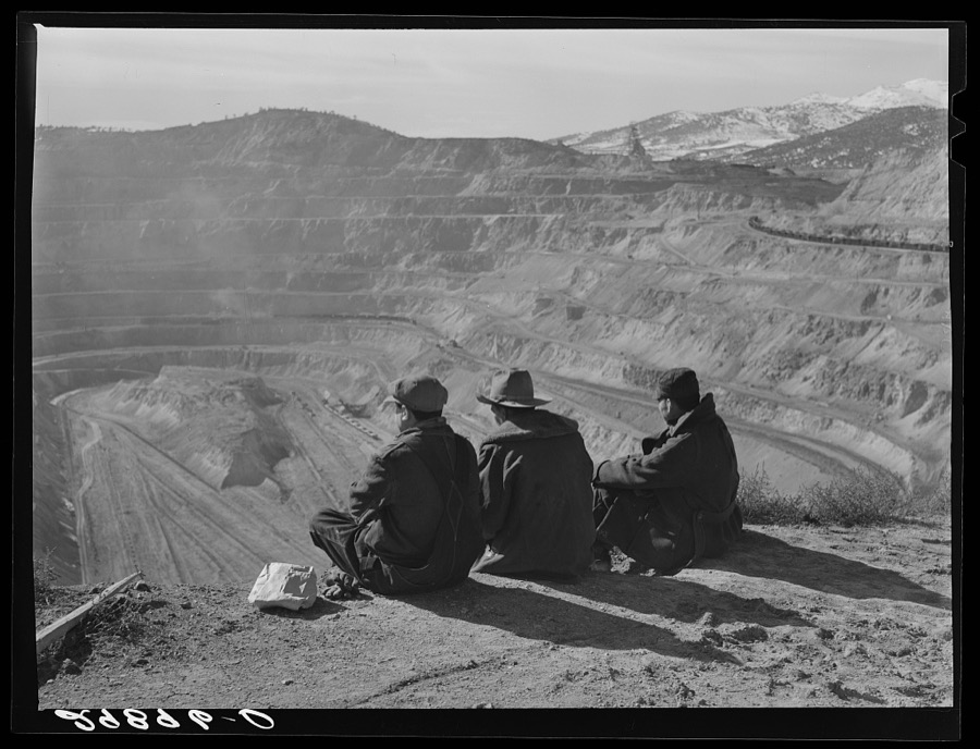 Workers sitting at edge of copper pit. Ruth, Nevada
