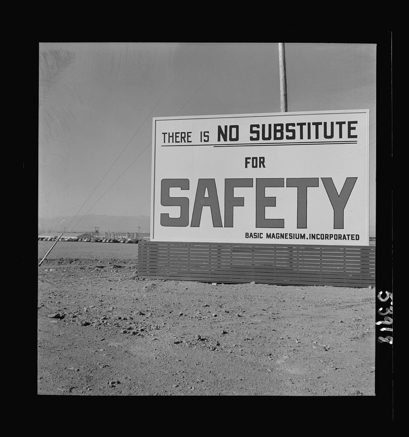 Las Vegas, Nevada. Billboards on the grounds of the gigantic plant of Basic Magnesium Incorporated, one of which shows tracer bullets and reads "MacArthur's job is fighting. OURS is magnesium"