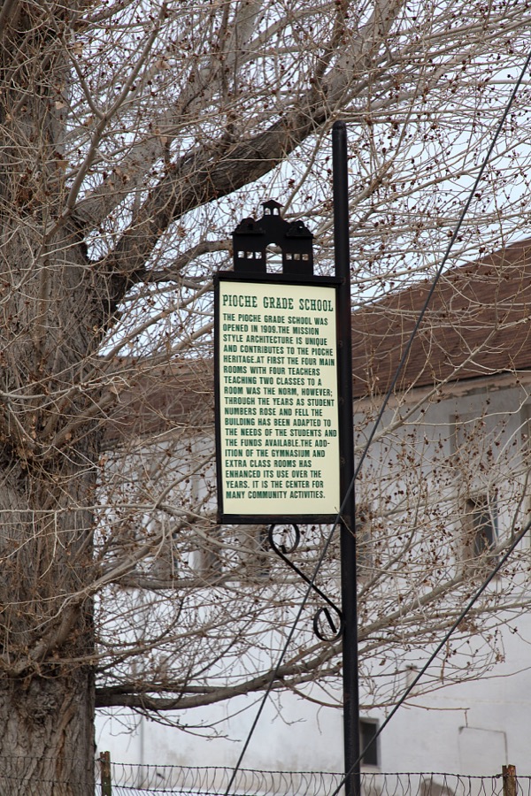 Sign by the historic Mission-style Pioche Grade School, which opened in 1909 in the old mining town of Pioche, which appears to hang along the side of a mountain and in a bowl below in Nevada's high desert, near the state's eastern border with Utah