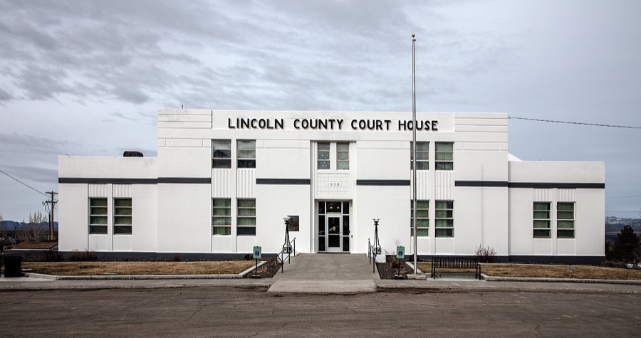 The small, Art Moderne-style Lincoln County Courthouse, which in 1938 replaced a larger and grander 1872 "Million Dollar Courthouse," whose original cost estimate far exceeded initial estimates and was financed with bonds totaling nearly 1 million dollars, in the old mining town of Pioche, which appears to hang along the side of a mountain and in a bowl below in Nevada's high desert, near the state's eastern border with Utah