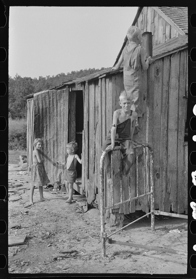 Son of day laborer resting on a wheel barrow, McIntosh County, Oklahoma