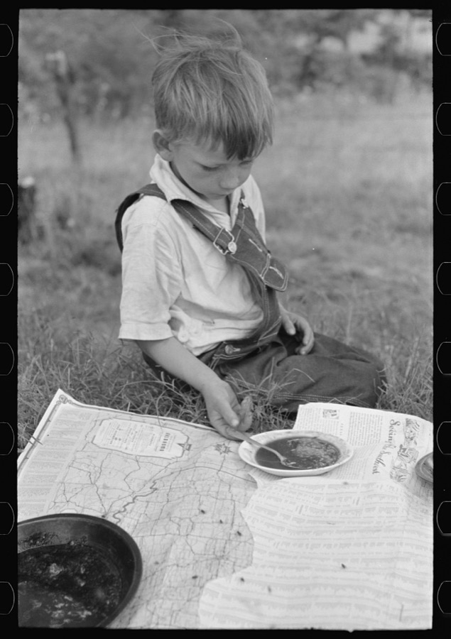 Son of white migrant eating lunch of blackberry pie along the highway east of Fort Gibson, Oklahoma