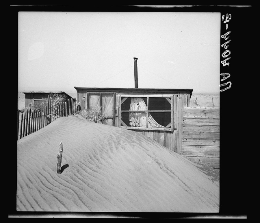 Sand piled up in front of outhouse on farm. Cimarron County, Oklahoma