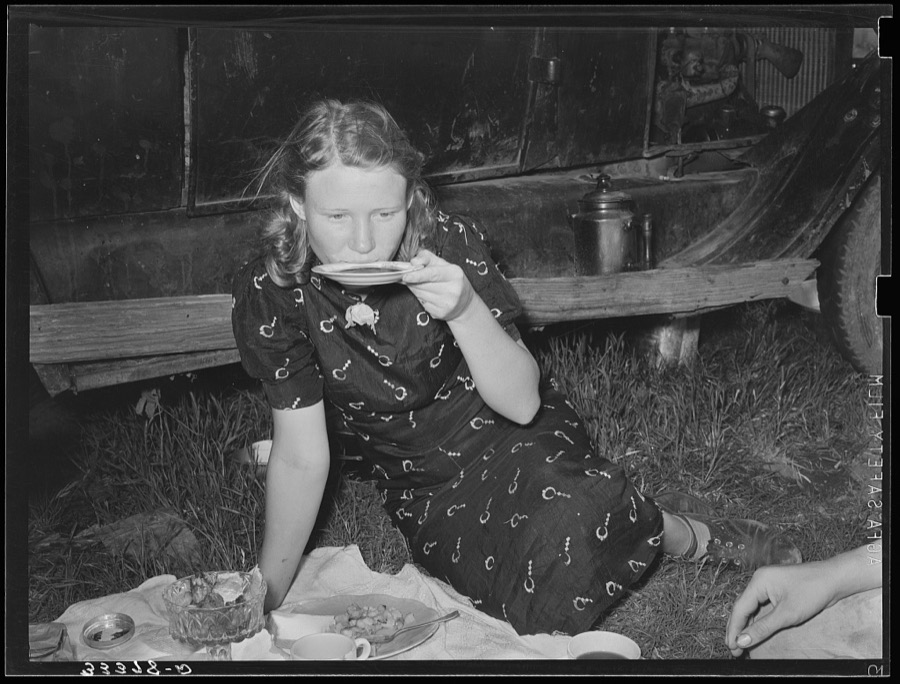 Migrant woman drinking coffee from saucer while camped near Prague, Oklahoma