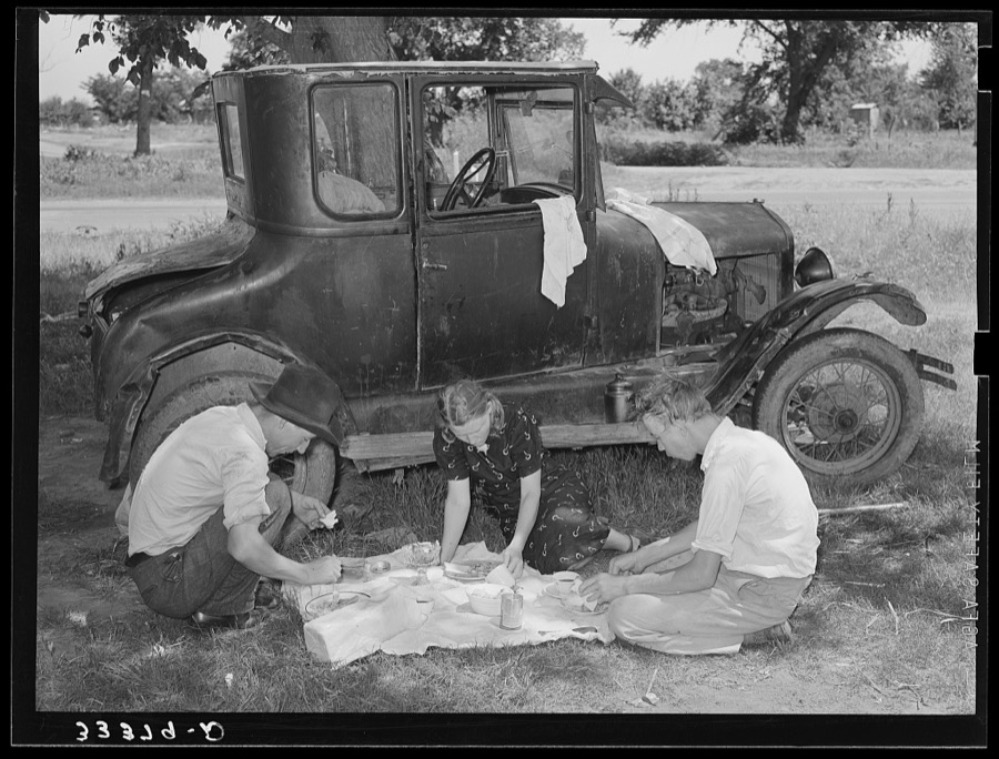 Migrant workers eating dinner by the side of their car while they are camped near Prague, Oklahoma. Lincoln County