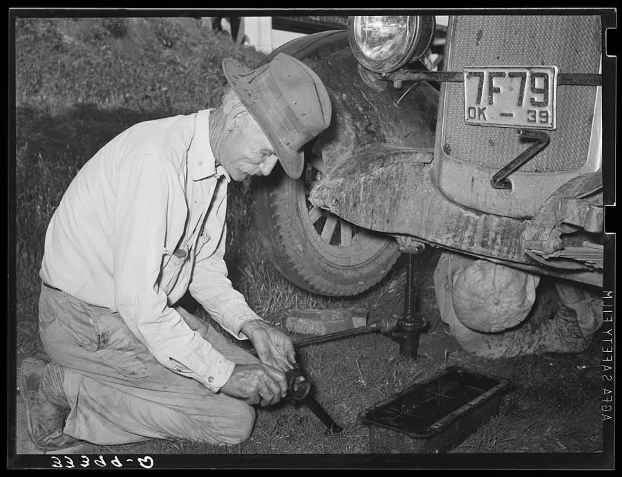 Father of migrant steeple-jack putting bolts in connecting rod while camped near Prague, Oklahoma. Lincoln County