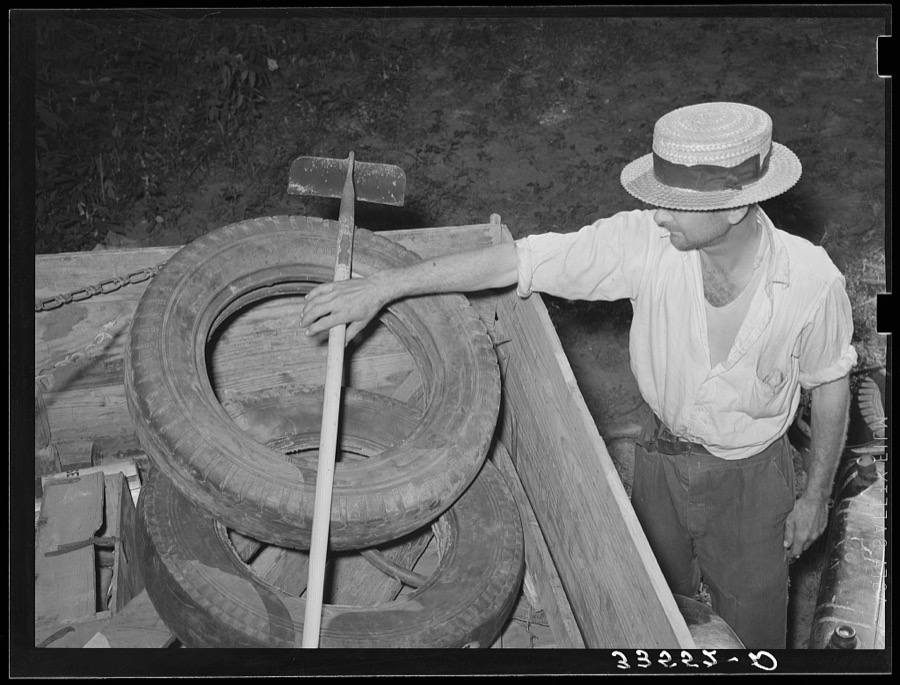 Migrant worker from Texas reaching for hoe in back of his automobile. Wagoner County, Oklahoma