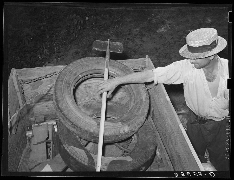 Migrant worker from Texas reaching for hoe in back of his automobile. Wagoner County, near Tullahassee, Oklahoma