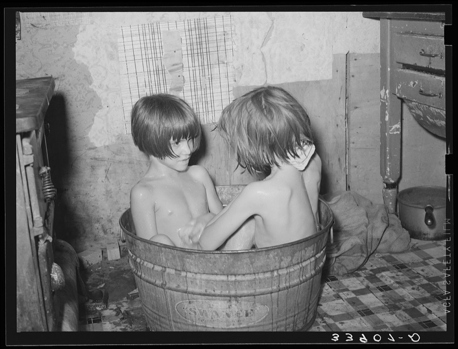 Children taking bath in their home in community camp. Oklahoma City, Oklahoma. See general caption 21
