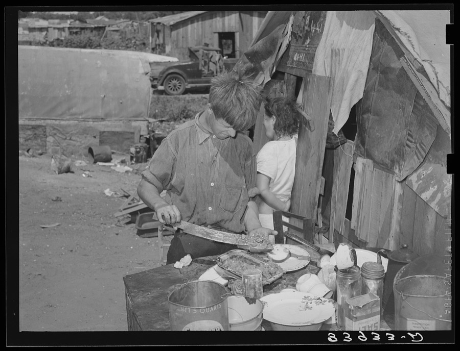 Boy living in camp near Mays Avenue making sandwich. This food is distributed by Saint Anthony's hospital after patients have been fed. This is the only foodline left in Oklahoma City, Oklahoma
