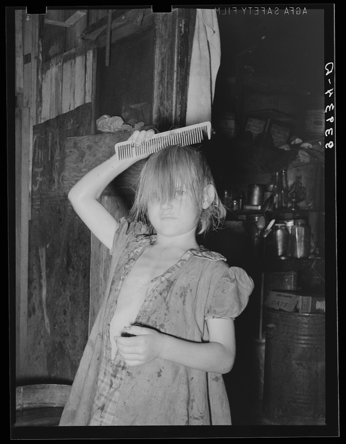 Little girl combing hair. She lives in camp near Mays Avenue. Oklahoma City, Oklahoma. See general caption no. 21