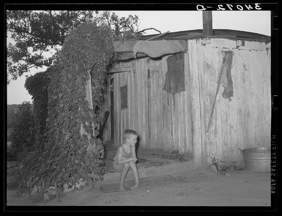 Young son of unemployed oil worker sitting on front porch of home. Seminole, Oklahoma