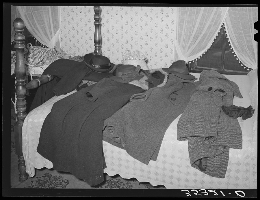 Coats of members of home demonstration club on bed during a meeting. McIntosh County, Oklahoma