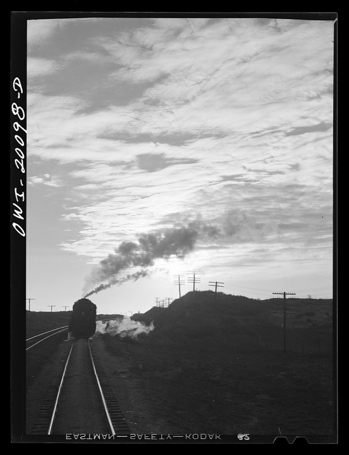 Curtis, Oklahoma. Helper engine leaving an Atchison, Topeka and Santa Fe train early in the morning after having helped push it from Belva, Oklahoma