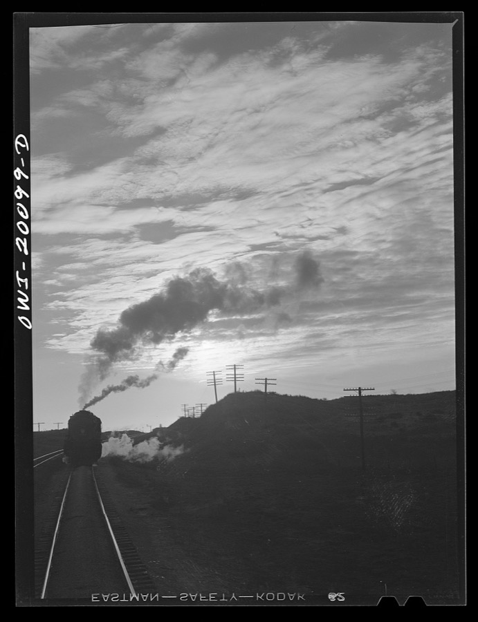 Curtis, Oklahoma. Helper engine leaving an Atchison, Topeka and Santa Fe train early in the morning after having helped push it from Belva, Oklahoma
