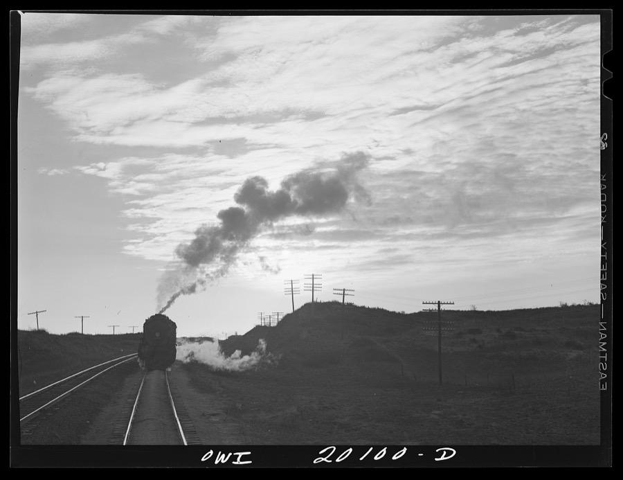 Curtis, Oklahoma. Helper engine leaving an Atchison, Topeka and Santa Fe train early in the morning after having helped push it from Belva, Oklahoma