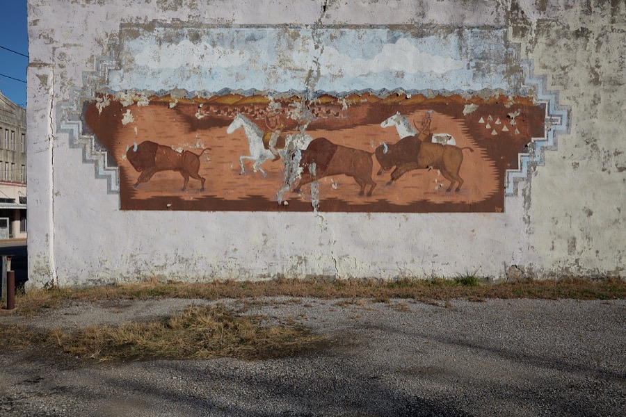 An aging, deteriorating mural in Barnsdall, a small city in Osage County, Oklahoma, depicting American Indians on a buffalo (or American bison) hunt
