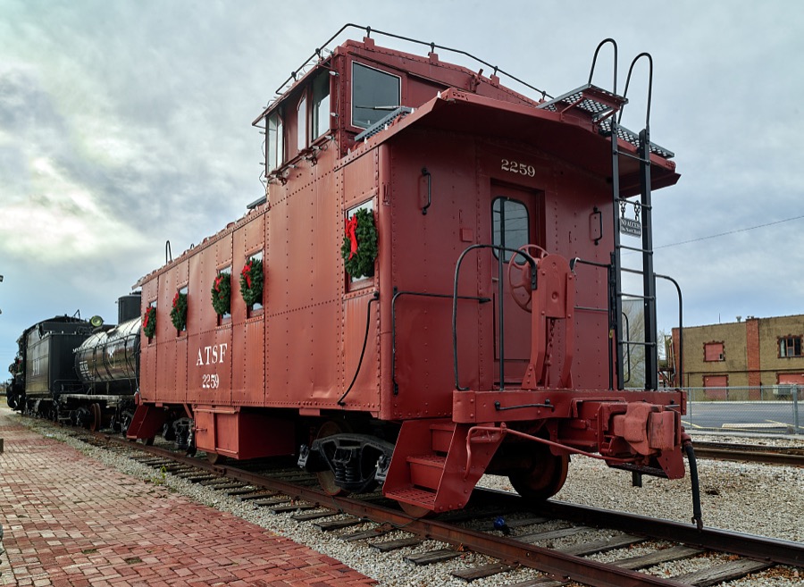 A caboose decorated with wreaths for Christmas brings up the rear of a historic Atchison, Topeka & Santa Fe train at Union Depot in Bartlesville, Oklahoma