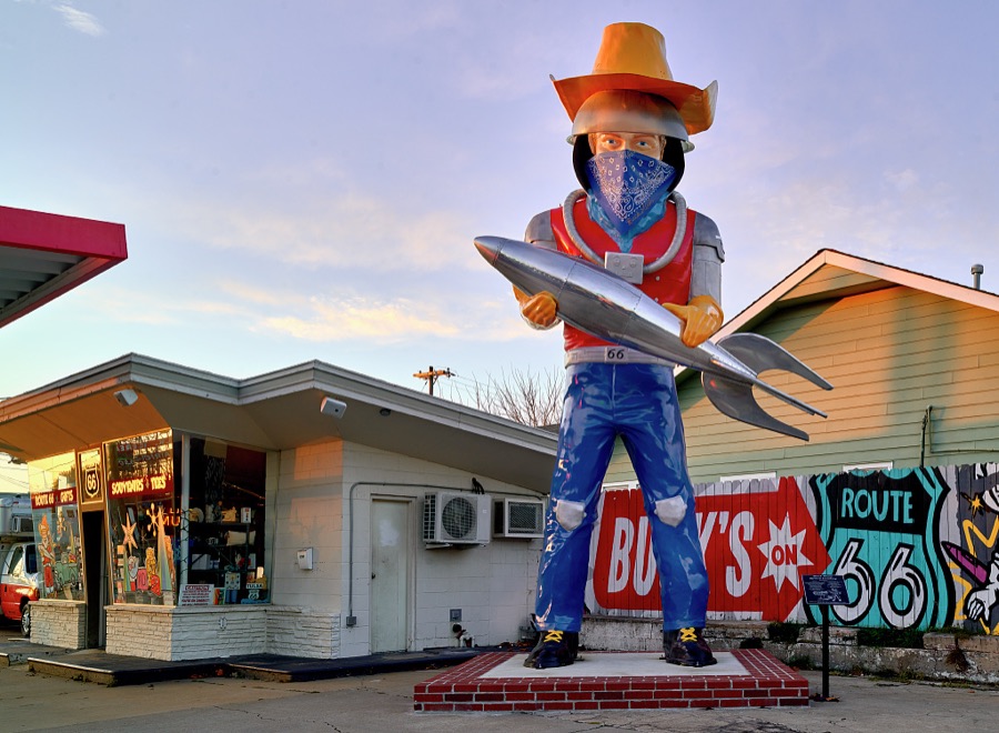 A jet-age "Muffler Man" (wearing an anti-coronavirus pandemic face mask in 2020) overlooks old U.S. Highway 66 as it winds through Tulsa, Oklahoma