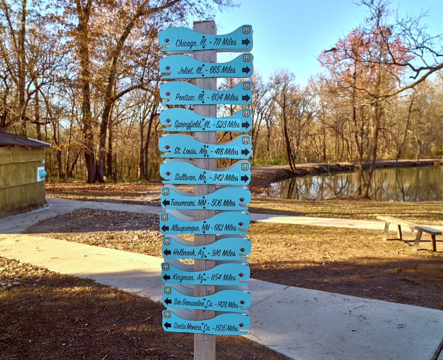 Whale-ish directional signs, light blue, of course, welcome visitors to the Blue Whale of Catoosa roadside park in the small Oklahoma city of the same name