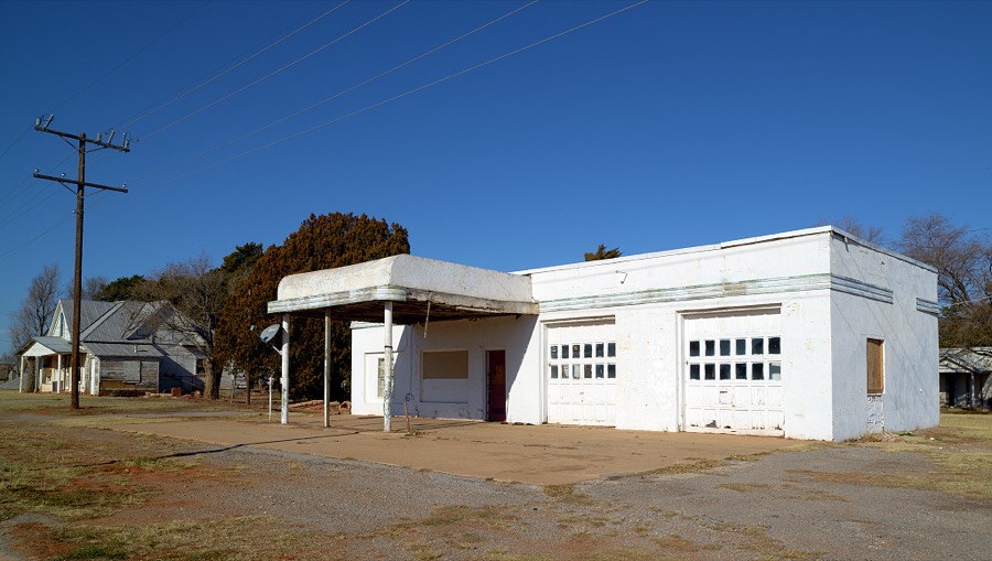 An old, abandoned, but not so old that it didn't have a satellite dish mounted on it, gas station or repair shop in Canute, Oklahoma