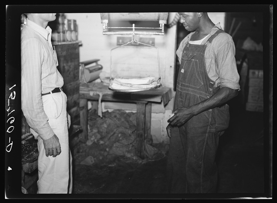 Weighing fatback in country grocery store. Florence County, South Carolina