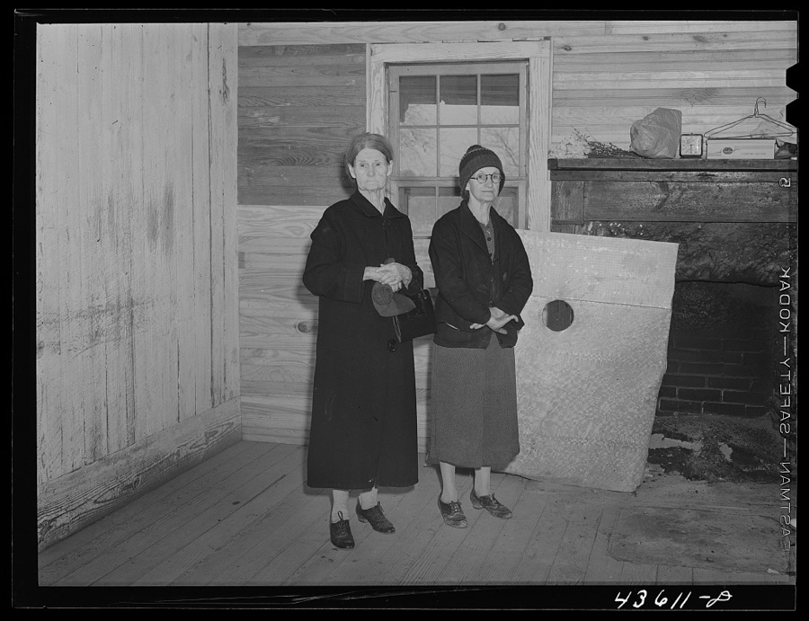 Mrs. Harvey and a neighbor watching her belongings being moved out of her house in the Camp Croft area near Whitestone, South Carolina